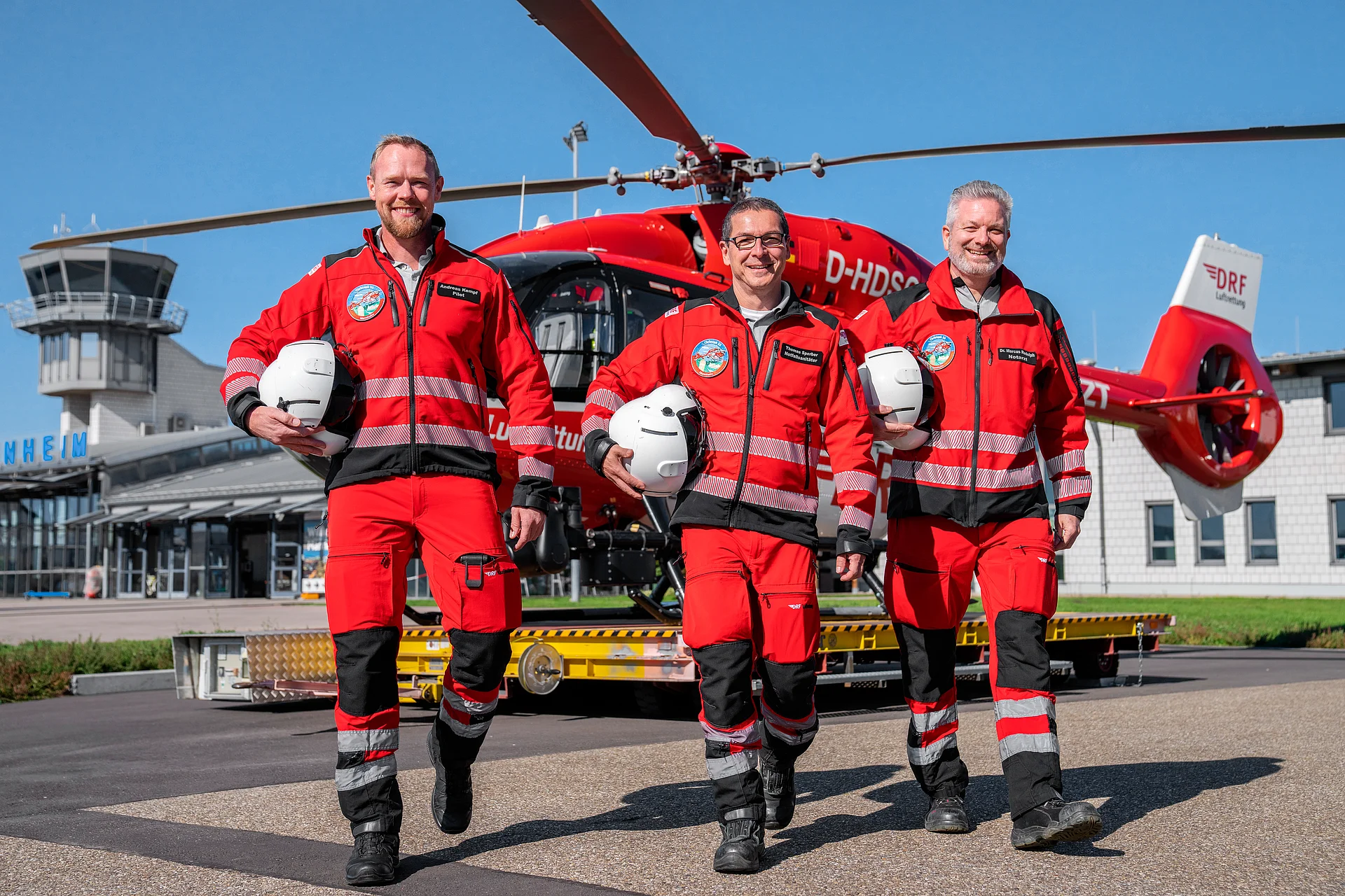 Einsatzcrew der DRF Luftrettung neben dem Rettungshubschrauber Christoph 53 am Flughafen Mannheim